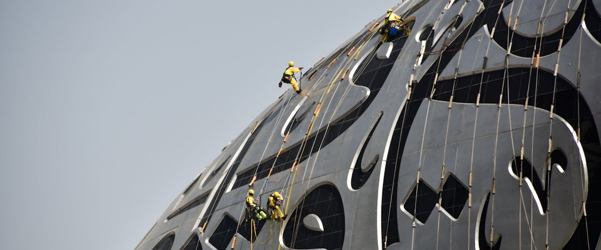 Construction workers climbing a building with safety gear in the Middle East